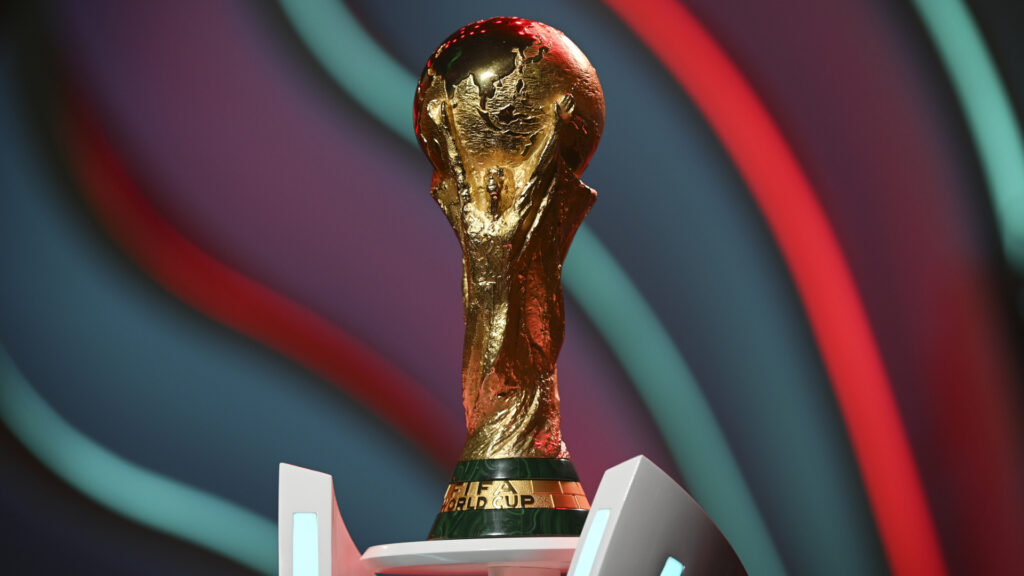 Qatar World Cup 2022 Trophy in front of a colorful banner